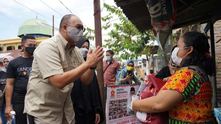 Anggota DPR RI Andre Rosiade saat menyerahkan langsung sembako kepada salah seorang warga.