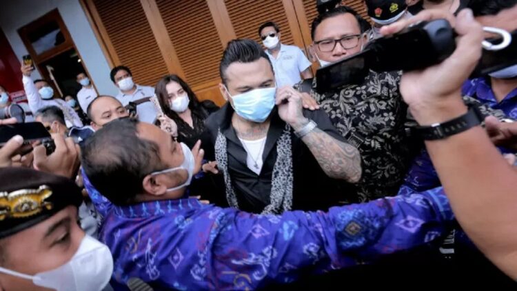 Jerinx SID Jadi Tersangka Kasus Pengancaman di Medsos 1 Penabuh drum Superman is Dead I Gede Ari Astina alias Jerinx (tengah) berjalan meninggalkan Lapas Kerobokan, Bali, Selasa (8/6/2021). (Antara)