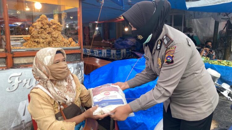 Personel Polres Padangpanjang membagikan Sembako kepada warga terdampak Covid-19.
