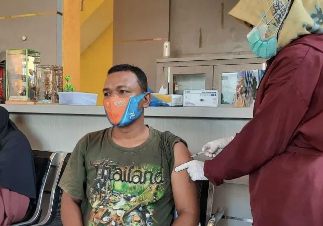 Pedagang dan Pengunjung Pantai Gandoriah Pariaman Antusias Ikuti Vaksinasi Covid-19 1 Warga setempat menerima vaksin Covid-19 pada pelaksanaan vaksinasi massal yang dilaksanakan Pemko Pariaman, Sumbar bersama TNI dan Polisi setempat di objek wisata Pantai Gandoriah.