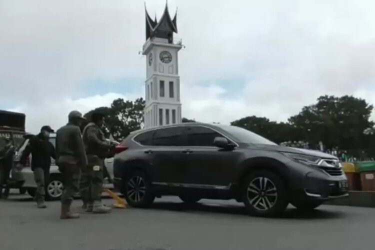 Kendaraan yang digembok petugas karena parkir sembarangan di pedestrian Jam Gadang, Kota Bukittinggi.