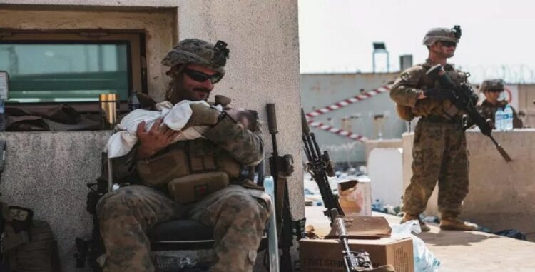 Marinir AS yang ditugaskan di Unit Ekspedisi Kelautan (MEU) ke-24 menggendong bayi saat evakuasi di Bandara Internasional Hamid Karzai, Kabul, Afghanistan, dalam foto yang diambil Jumat (20/8/2021). Sgt. Isaiah Campbell/U.S. Marine Corps/Handout via REUTERS/AWW/djo