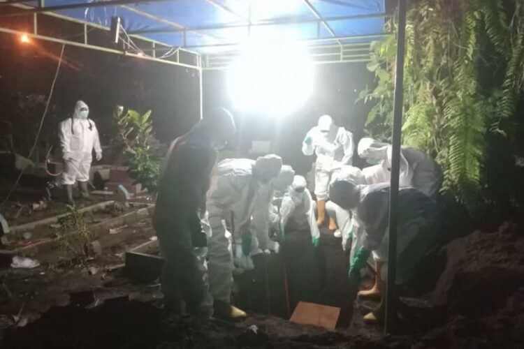 Relawan PMI Pasaman Barat saat memakamkan pasien Covid-19 yang meninggal dunia, Sabtu (31/7/2021) malam.