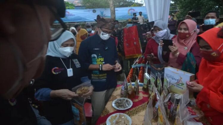 Menparekraf Sandiaga Uno (ketiga kiri) bersama istri, Nur Asia Uno (kedua kiri), membeli produk UMKM ikan bilih goreng saat berkunjung ke Kampuang Minang Nagari Sumpu, di Kabupaten Tanah Datar, Sumatera Barat, Sabtu (28/8/2021). ANTARA/Iggoy el Fitra