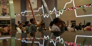 Sejumlah pengunjung duduk berlatar belakang pergerakan Indeks Harga Saham Gabungan (IHSG) di Bursa Efek Indonesia, Jakarta. (ANTARA FOTO/Sigid Kurniawan)