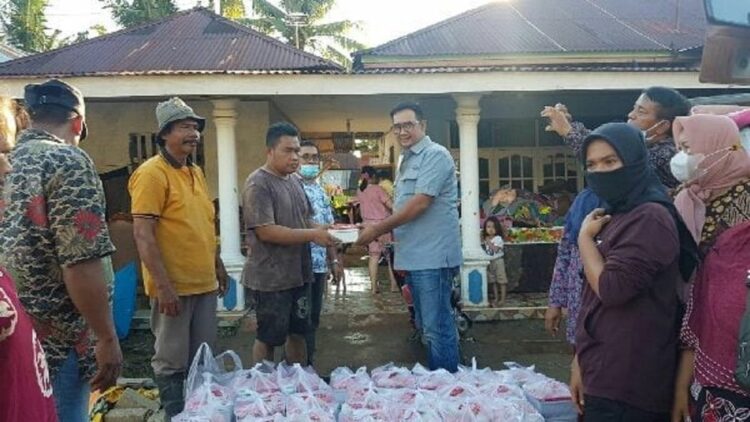 Ketua Umum JAPNAS BERBAKTI Sumatera Barat Dafrawira De Hansen saat membagikan nasi bungkus untuk masyarakat terdampak banjir di Padang.