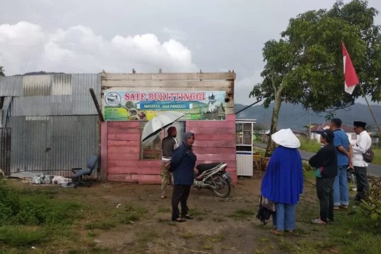 Warga sedang berada di lokasi warung yang rusak akibat angin piting beliung, Sabtu (21/8).
