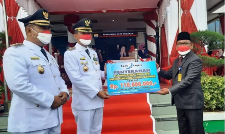 Pimpinan Cabang Bank Nagari Pariaman, Sumbar Ibnu Supriadi (kanan) secara simbolis menyerahkan CSR perusahaan itu kepada Wali Kota Pariaman Genius Umar (tengah) usai Upacara Peringatan HUT Kemerdekaan ke-76 RI di Pariaman, Selasa. (Antara/Aadiaat M. S.)