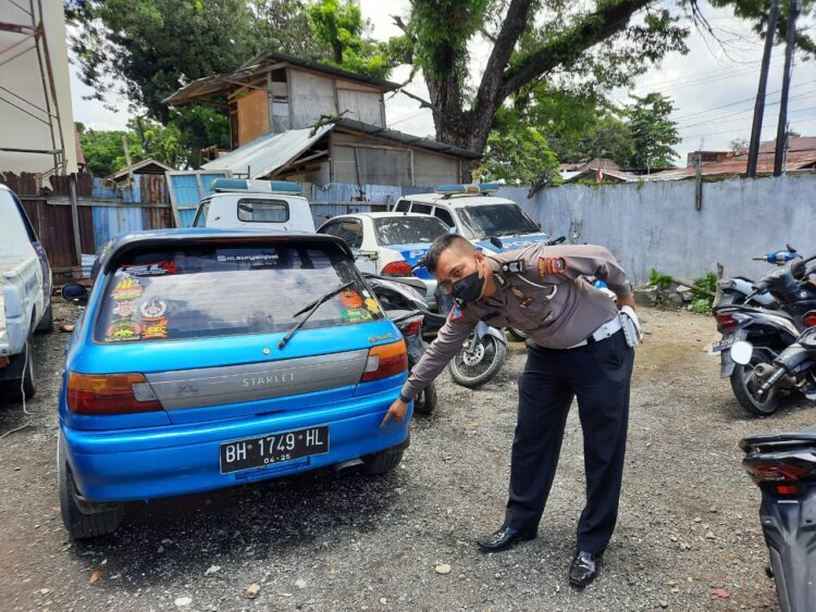 Dihentikan saat Patroli, Pengemudi Sedan di Padang Ini Tancap Gas dan Hampir Tabrak Petugas 1 Petugas Satlantas Polresta Padang menunjukkan mobil sedan yang mencoba kabur saat dipatroli. Mobil ini juga menggunakan knalpot racing. (IST)