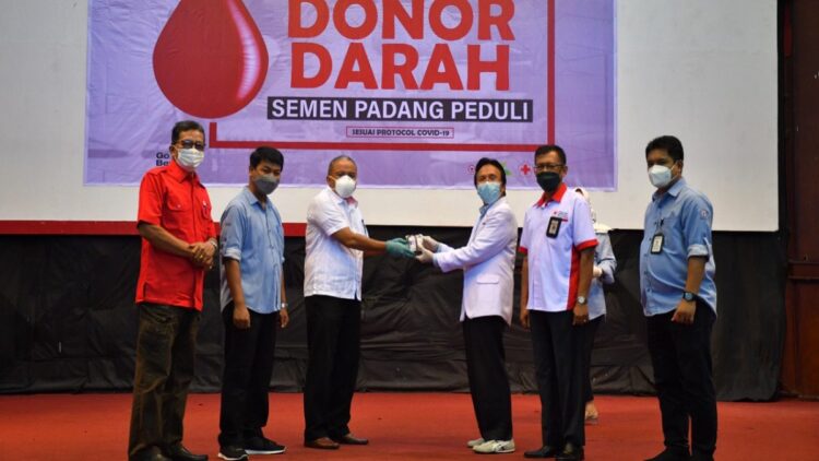 Kepala Departemen Komunikasi  dan Hukum Perusahaan PT Semen Padang Oktoweri (tiga dari kiri) menyerahkan kantong darah yang terkumpul kepada  Kepala Unit Transfusi Darah PMI Padang dr. Widyarman.