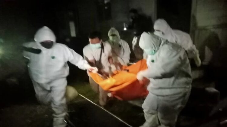 Anggota Polres Pasaman menggunakan Alat Pelindung Diri (APD) mengevakuasi jenazah Bujang di Lubuk Sikaping.  (Antara/Septria Rahmat)