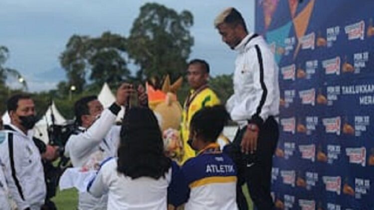 Ketua KONI Pasaman kalungkan medali di PON Papua.