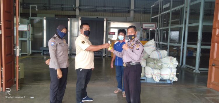 Kapolsek Kawasan BIM Ipda Akbar Kharisma Tanjung membagikan ratusan hand sanitizer. (IST)