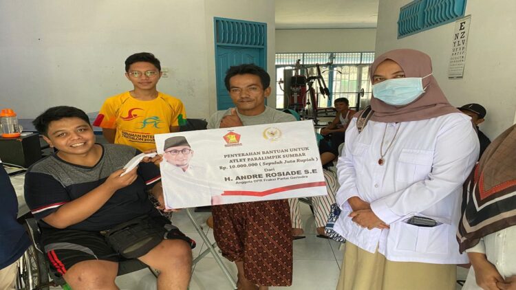 Salah seorang atlet paralimpik semringah menerima bantuan dari Andre Rosiade yang diserahkan Pengurus Gerindra Sumbar Nurhaida. (IST)