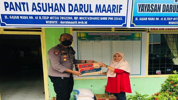 Kapolsek Kawasan BIM Ipda Akbar Kharisma Tanjung menyerahkan bansos ke pihak panti asuhan. (IST)