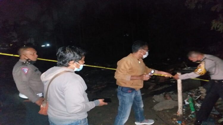 Anggota polisi memasang garis polisi di lokasi kebakaran. (IST)