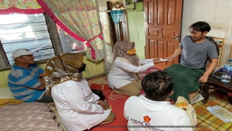 Pengurus DPD Gerindra Sumbar menyerhakan bantuan uang tunai dan sembako dari Andre Rosiade kepada Rio yang menderita lumpuh di Gates, Lubukbegalung, Padang. (IST)