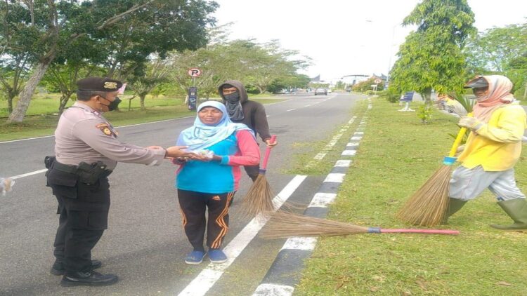 Jajaran Polsek Kawasan BIM membagikan sarapan pagi kepada petugas kebersihan di BIM. (IST)