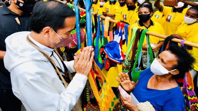 Presiden Jokowi membeli noken dari mama penjual di pinggir Jalan Raya Hawai Sentani, Jayapura, Papua, Jumat (01/10/2021). (Foto: BPMI Setpres/Laily)