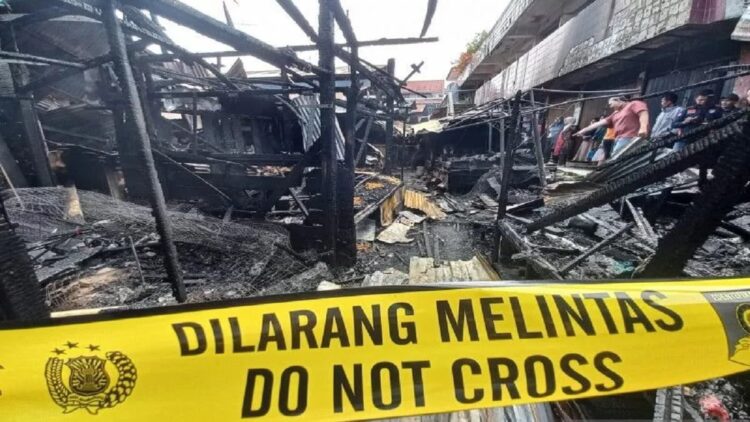 Polisi memasang police line di sekitar bangunan Pasar Bawah Kota Bukittinggi yang terbakar pada Rabu (24/11) sekitar pukul 00:45 WIB dini hari. (Antara/Alfatah)