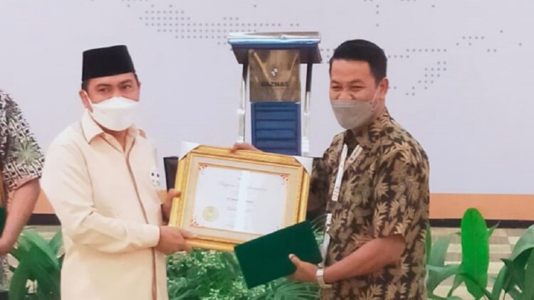 Wakil UPZ Baznas Semen Padang, Rinold Thamrin saat menerima penghargaan.
