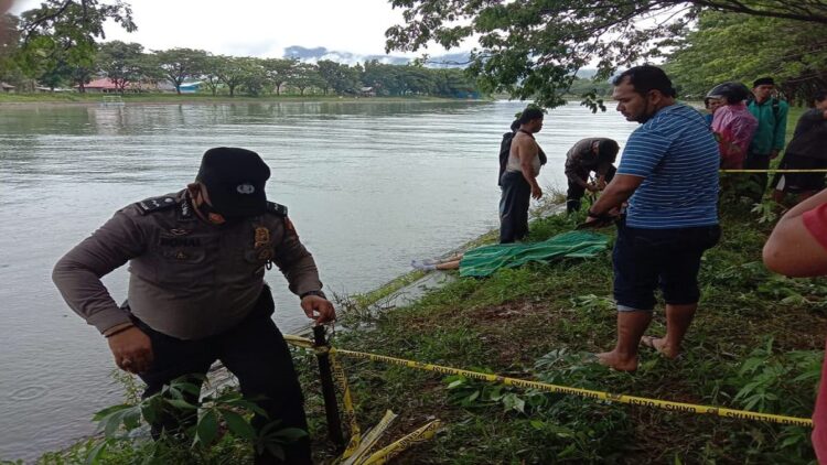 Geger, Mayat Perempuan Ditemukan Mengambang di Aliran Sungai Muaro Panjalinan, Padang 1 Polisi memasangi garis polisi di lokasi ditemukannya mayat di aliran sungai Muaro Panjalinan. (IST)