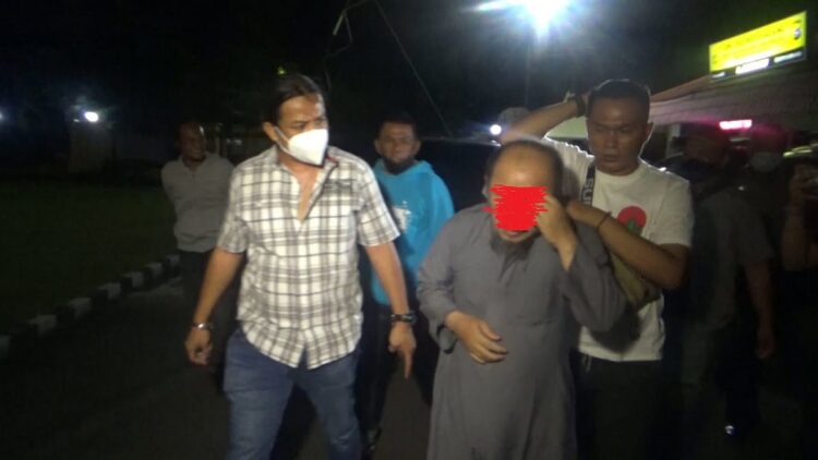 Terlihat personil Tim Klewang Aipda David Rico Darmawan membawa pelaku pelecehan seksual ke Polresta Padang. (IST)