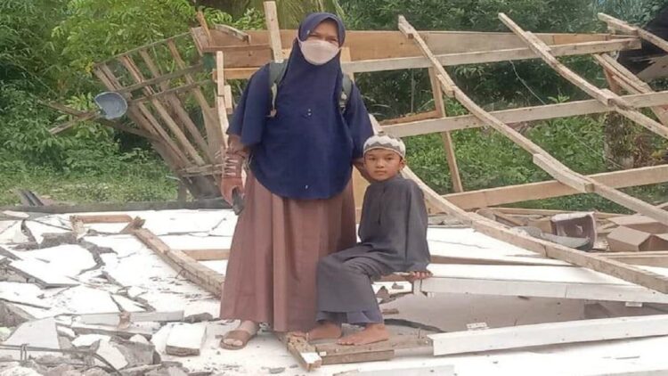 Zuldesni dan anaknya di reruntuhan rumah pasca perubuhan.