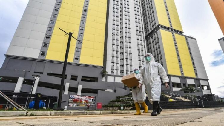 Pasien Omicron Lolos dari Wisma Atlet, Ini Klarifikasi Kemenkes 1 Petugas kesehatan Rumah Sakit Covid-19 Wisma Atlet Kemayoran Jakarta berjalan membawa kotak obat pasien. (Antara)