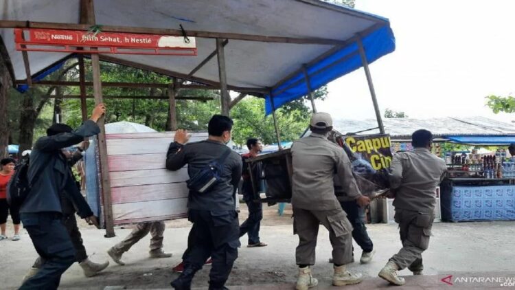 Sejumlah anggota Satpol PP Pariaman, Sumbar mengangkat meja lapak pedagang di objek wisata Pantai Gandoriah. (Antarasumbar/Aadiaat M.S)