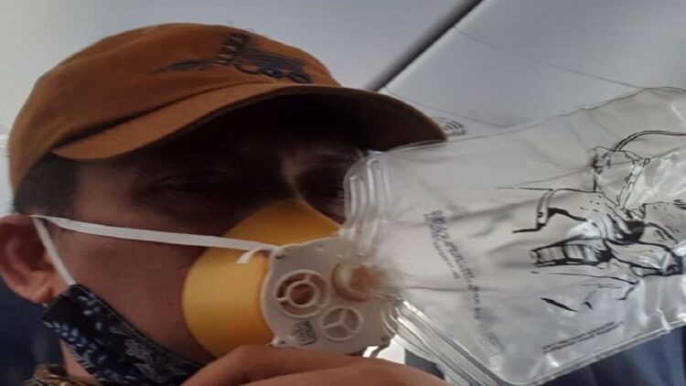 Evi Yandri Rajo Budiman mengenakan oksigen saat pesawat yang ditumpanginya hilang tekanan dan turun mendadak.