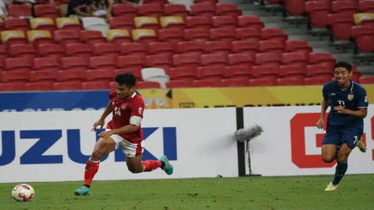 Bek tim nasional Indonesia Asnawi Mangkualam Bahar (kiri) menggiring bola melewati pemain Thailand Bordin Phala dalam laga leg pertama final Piala AFF 2020 di Stadion Nasional, Singapura, Rabu (29/12/2021). Indonesia kalah 0-4 pada pertandingan tersebut. (ANTARA/HO/PSSI)