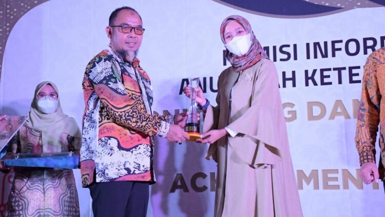 Wakil Ketua Komisi Informasi Sumbar Arif Yumardi (kiri) menyerahkan Piala Peringkat ke-1 Keterbukaan Informasi Publik untuk kategori BUMN/BUMD di Sumbar kepada Kepala Unit Humas & Kesekretariatan PT Semen Padang Nur Anita Rahmawati,  di Bukittinggi,  Senin  (6/12/2021).