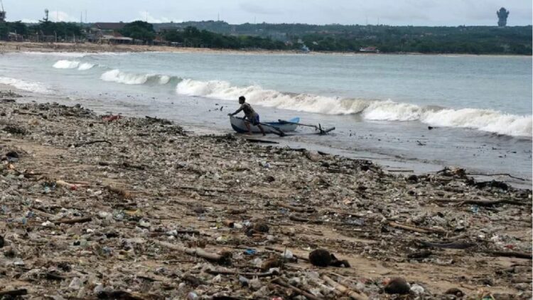 Penggunaan Plastik Belanja Online, Tambah Kontribusi Sampah ke Laut 1 Nelayan beraktivitas di dekat tumpukan sampah yang berserakan di Pantai Kedonganan, Badung, Bali, Selasa (7/12/2021). (ANTARA FOTO/Nyoman Hendra Wibowo/aww)