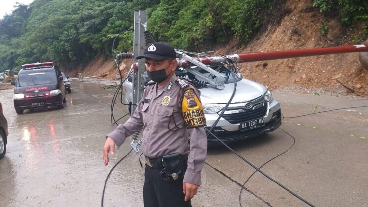 Tiang Listrik Timpa Satu Unit Mobil di Lubuk Paraku, Tidak Ada Korban 1 Petugas dari Polsek Lubuk Kilangan mengatur lalu lintas menjelang evakuasi mobil yang tertimpa tiang listrik di kawasan Lubuk Paraku, Kecamatan Lubuk Kilangan, Kota Padang, Jumat pagi.