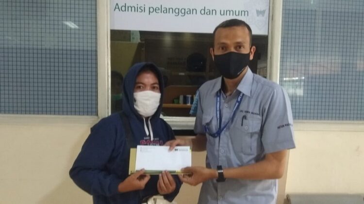 Staf UPZ Baznas Semen Padang, Toni (kanan) menyerahkan bantuan biaya berobat kepada keluarga penerima manfaat bantuan kesehatan yang dirawat di Rumah Sakit Siti Rahmah pada Desember 2021.