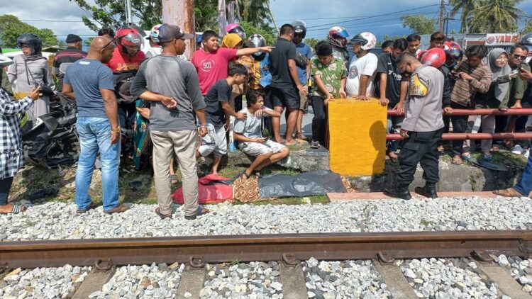 Pemotor yang meninggal dunia usai dihantam kereta api di Lubuk Buaya jelang dievakuasi oleh petugas polisi dan Basarnas. (Polsek Koto Tangah)