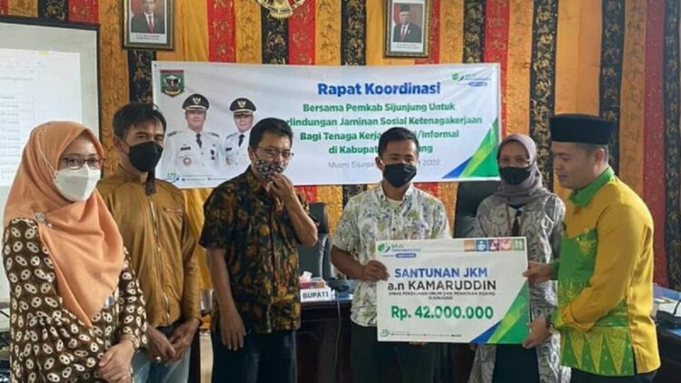 Pemkab Sijunjung bakal Lindungi Mubaligh dan Petani dengan BP Jamsostek 1 Wakil Bupati Sijunjung, Iraddatillah memberikan santunan Jaminan Kematian BPJAMSOSTEK kepada ahli waris honorer di Pemkab Sijunjung usai sosialisasi jaminan sosial bagi pekerja mandiri, Senin. (Antarasumbar/HO-BPJamsostek)