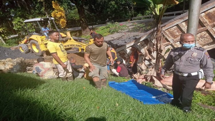 Terlihat salah satu personel Polsek Lubuk Kilangan Bripka Oyon Tanjung mengevakuasi korban yang terhimpit. (IST)