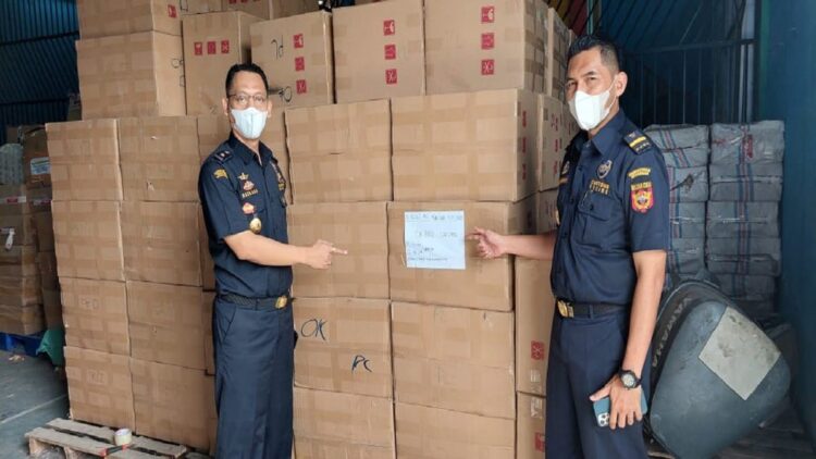 Kasi Penindakan dan Penyidikan Kantor Bea Cukai Teluk Bayur  Baskara Priya Utama bersama rokok illegal yang berhasil disita. (IST)
