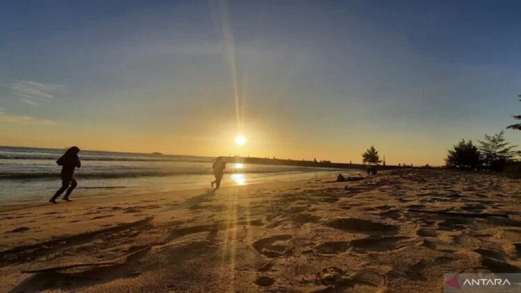 Promosikan Pariaman sebagai Kota Matahari Terbenam, Pemko Adakan Lomba Foto Sunset 1 Dua wisatawan sedang berlari di Pantai Pariaman, Sumbar saat matahari akan terbenam. (Antara/Aadiaat M.S)