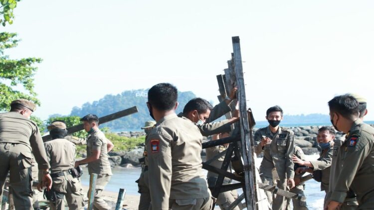 Ganggu Kenyamanan Pengunjung, Tim Gabungan Bongkar Lapak PKL di Pantai Padang 1 Personel Satpol PP menertibkan sejumlah lapak PKL di sepanjang Pantai Padang. (IST)
