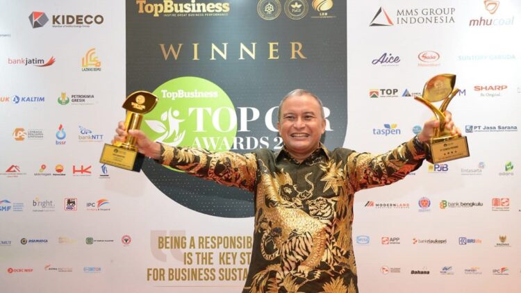Direktur Keuangan dan Umum PT Semen Padang, Oktoweri memperlihatkan dua penghargaan TOP CSR Awards 2022.