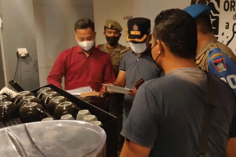 Petugas Satpol PP memeriksa kafe yang diduga tak menerapkan protokol kesehatan di Padang.