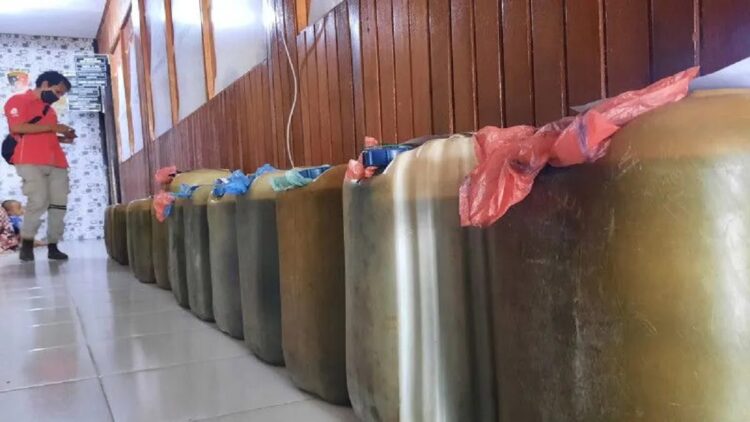 Salah seorang wartawan sedang mengambil gambar barang bukti BBM bersubsidi di Polres Pariaman, Sumbar sebagai barang bukti kasus dugaan penimbunan BBM di daerah tersebut, Senin. ANTARA/Aadiaat M. S.