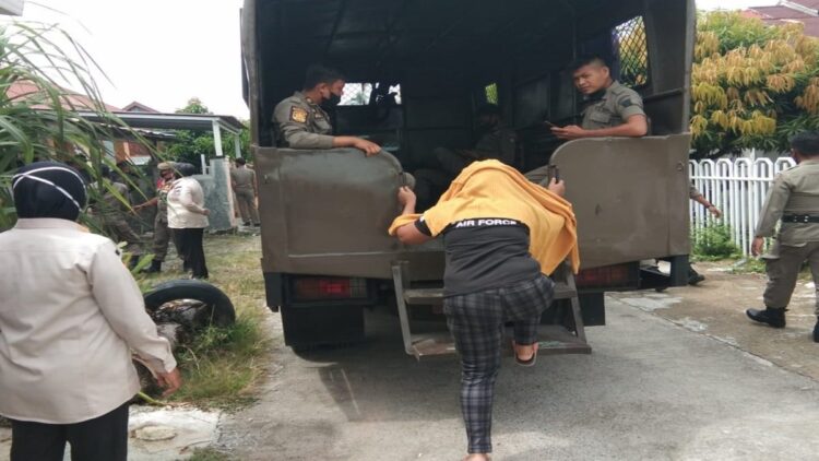 Tiga orang wanita diangkut ke atas truk usai razia panti pijat berkedok salon di Kota Padang. (IST)