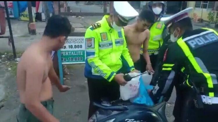 Puluhan Kendaraan Dikandangkan usai Terjaring Razia di Padang 1 Polisi memeriksa barang bawaan pengendara saat terjaring razia di operasi cipta kondisi Polresta Padang. (IST)