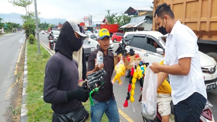 Sisihkan Gaji, Polisi di Padang Ini Tebar Kebaikan Ramadhan lewat Nasi Bungkus Gratis 1 Briptu Fandri Irawan membagikan nasi bungkus ke pedagang asongan di kawasan lampu merah Simpang Lubuk Minturun, Kota Padang. (IST)