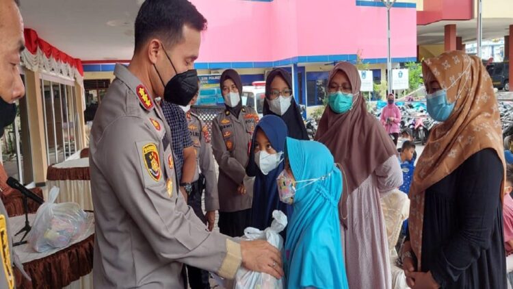 Kapolresta Padang menyerahkan santunan uang kepada anak yatim di Kota Padang. (IST)
