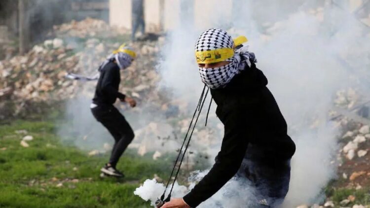 Dilempari Batu dan Bom Molotov, Tentara Israel Tembak Mati Seorang Remaja Palestina 1 Seorang demonstran Palestina bersiap untuk melemparkan kembali tabung gas air mata yang ditembakkan oleh pasukan Israel, Jumat (31/12/2021). REUTERS/Mohamad Torokman/aww/sa. (REUTERS/MOHAMAD TOROKMAN)